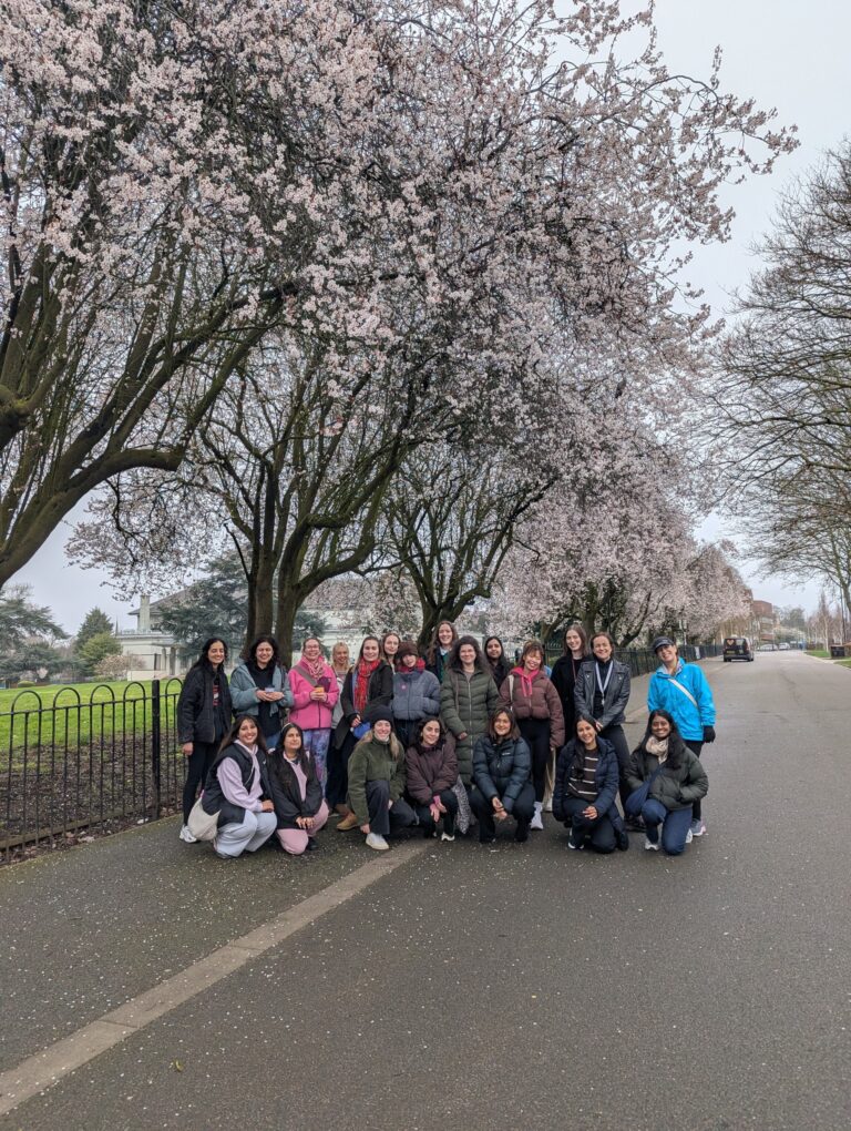 girls who walk leic group photo, standing in front of blossom trees during the fundraising event
