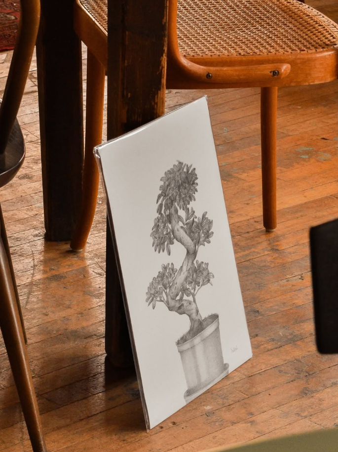 a pencil drawing resting on leg of a table